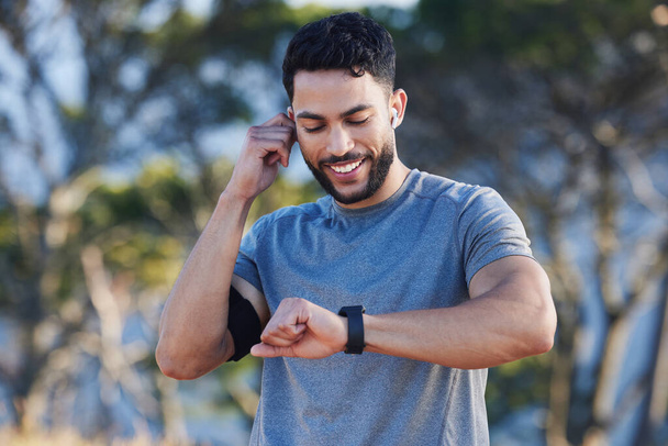 Man, runner and smartwatch outdoor for workout listening to music, radio or streaming on web. Training, running and fitness for guy with tech clock to check heart, blood pressure or steps in summer. - Zdjęcie, obraz