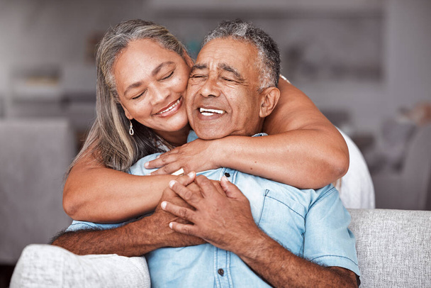 Glückliche Senioren-Paar, umarmen und entspannen in Liebe für Beziehung Bindung zusammen in zartem Glück zu Hause. Fröhliche ältere Männer und Frauen lächeln in der Hoffnung auf Romantik für das Altenheim auf dem Sofa. - Foto, Bild