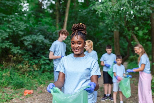 Vrijwilligers die afval ophalen uit het park, milieubewustzijn is belangrijk om onze planeet te redden - Foto, afbeelding