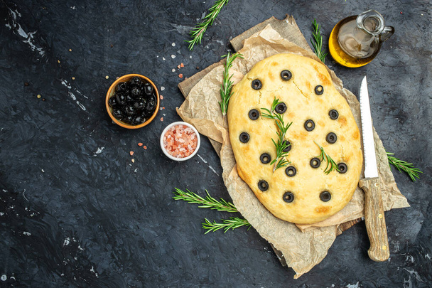 Homemade Italian Focaccia with rosemary and olive on a dark background. banner, menu, recipe place for text, top view. - Foto, imagen
