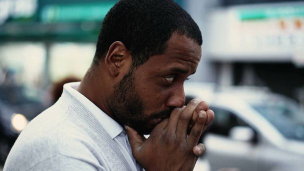 Un jeune homme spirituel noir priant dans la rue ayant l'ESPOIR et la Foi. African American prie sur le trottoir urbain de la ville - Photo, image