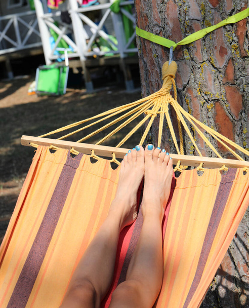 piernas delgadas de la muchacha joven que descansa en la hamaca en verano - Foto, Imagen