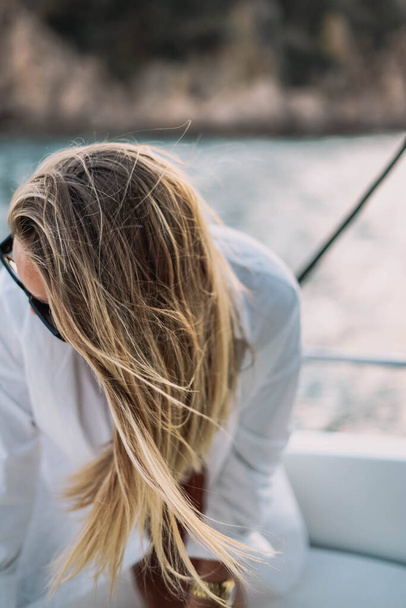 Blond model met zonnebril op een boottocht - Foto, afbeelding