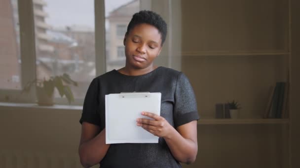 Afrikai amerikai lány rövid haj töprengő biracial gondolkodó nő beltéri gondolkodás ötletelés terv stratégia emlékezve gazdaság mappa papír írás ötletek keresi a megoldást a problémára - Felvétel, videó