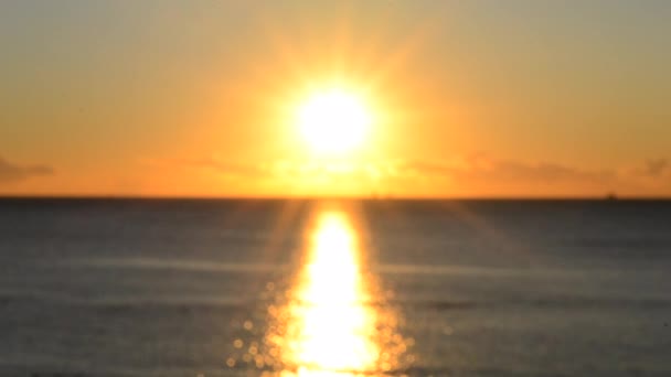 Zamazane tło. Słońce świeci na niebie o zachodzie słońca. Wschód słońca o zachodzie słońca. Słoneczna ścieżka, słoneczny chodnik na powierzchni fal morskich. Promienie słońca. Morski krajobraz. Naturalna rozmyta faktura bokeh - Materiał filmowy, wideo