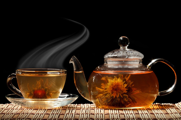 Glass teapot and a cup of green tea on a black background - Foto, Imagem