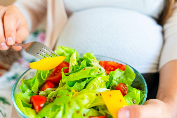 Pregnancy eating healthy salad. Happy pregnant woman eating nutrition food. People lifestyle food concept - Fotoğraf, Görsel