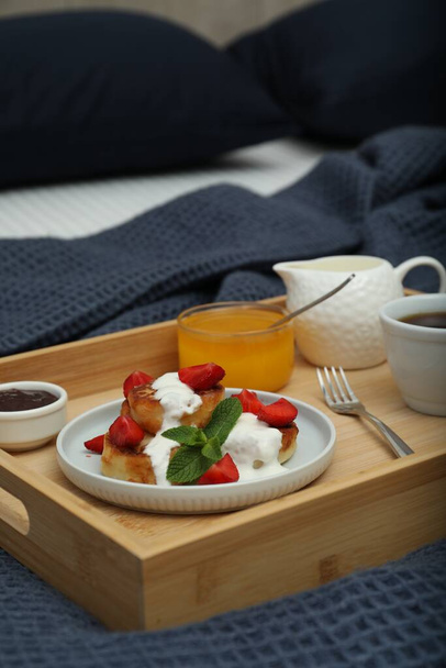 Cottage cheese pancakes with fresh strawberries, sour cream and mint served for breakfast on wooden tray, closeup - Φωτογραφία, εικόνα