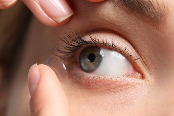 Woman putting in contact lens, closeup view - Photo, image