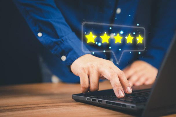 Man using laptop computer to rate service experience in application online. Customer reviews opinion poll satisfaction survey and testimonial. - Photo, Image