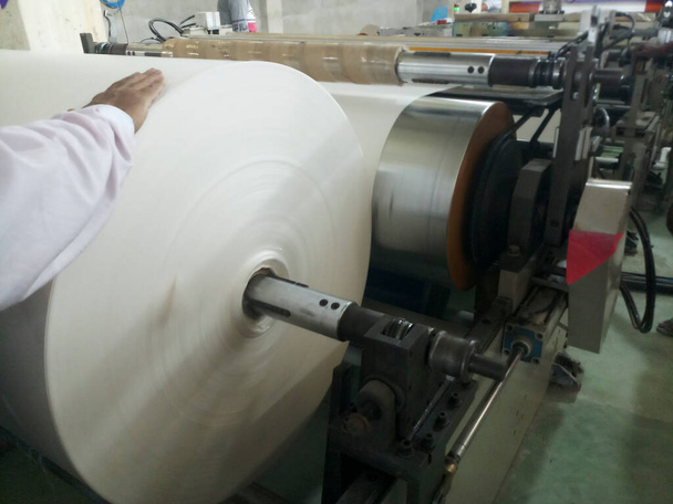 PE, polyeteenipinnoite kone käynnissä sisällä tehdas. PE-pinnoitetta käytetään paperikuppien valmistukseen. - Valokuva, kuva