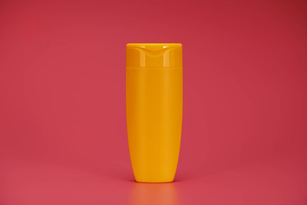 Blank Label Shampoo Κίτρινο μπουκάλι ή αφρόλουτρο σε ροζ φόντο - Φωτογραφία, εικόνα