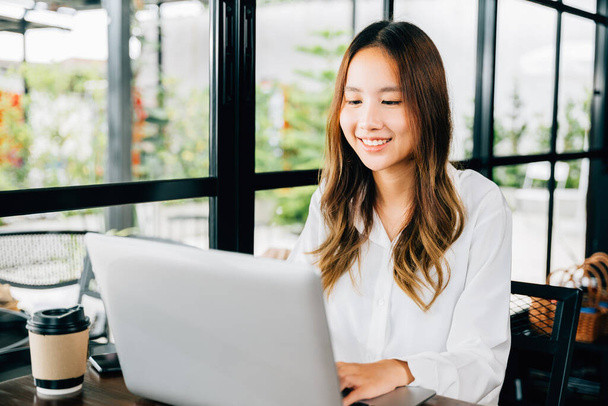 Azji młody biznes kobieta styl życia za pomocą laptopa w kawiarni kawiarnia, Szczęśliwy piękny freelancer wpisując klawiaturę na laptopie, pracy online poza biurem - Zdjęcie, obraz