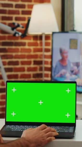 Függőleges videó: Modern menedzser néz laptop zöld kijelző és elemzése üres chroma kulcs sablont hordozható számítógépen. Ellenőrzése elszigetelt háttér és mockup copyspace on pc. - Felvétel, videó