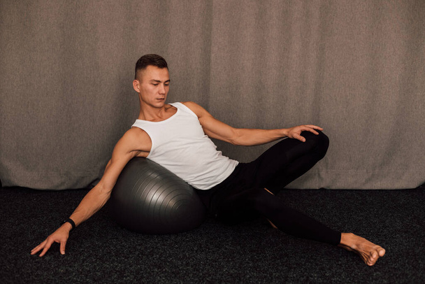 Молодой спортсмен выполняет упражнения дома. Фитнес фитнес йога пилатес. Высокое качество фото - Фото, изображение