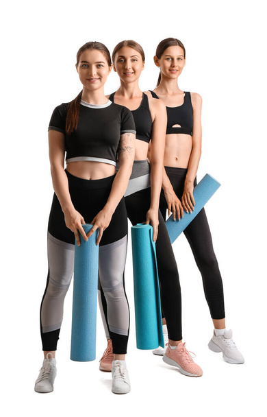 Sporty young women with yoga mats on white background - Fotografie, Obrázek