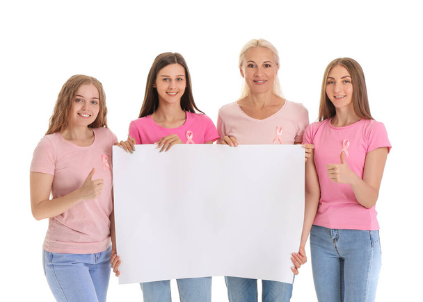 Mooie vrouwen met roze bewustwordingslinten en blanco poster op witte achtergrond. Borstkankerconcept - Foto, afbeelding