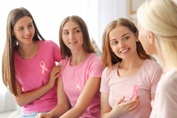 Beautiful women with pink awareness ribbons at home. Breast cancer concept - Photo, Image