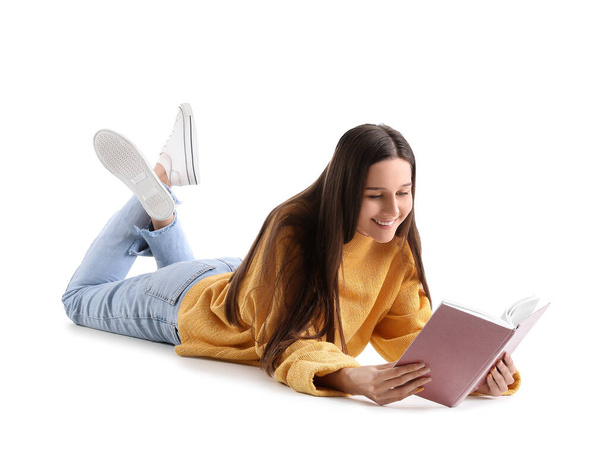 Beautiful woman in yellow sweater reading book on white background - Fotografie, Obrázek