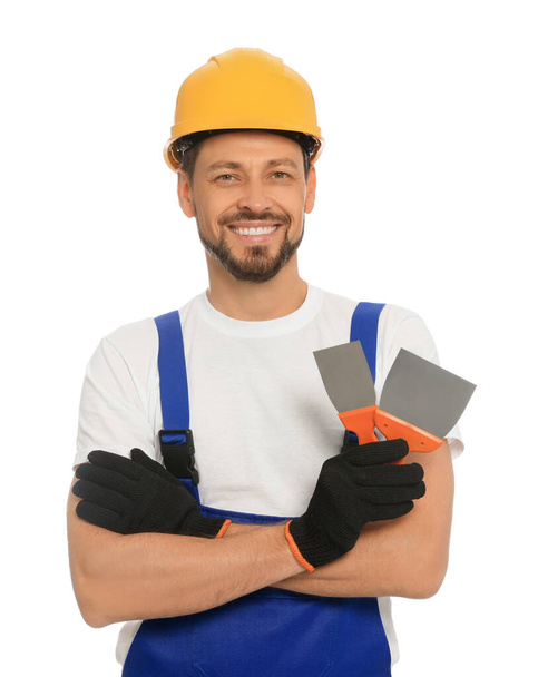 Professional worker with putty knives in hard hat on white background - Foto, immagini