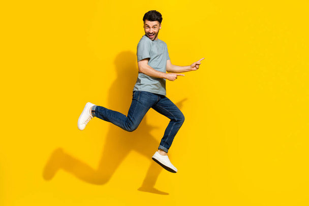 Full length photo of positive funky man dressed trendy clothes arm presenting empty space isolated on yellow color background. - Valokuva, kuva