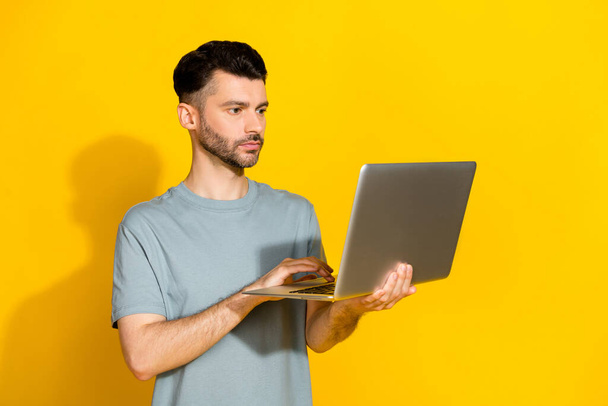 Photo of serious confident professional businessman hold new netbook typing programmer it development owner isolated on bright yellow color background. - Foto, afbeelding