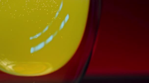 Close-up van een vers sinaasappelsap dat in een glas wordt gegoten. Een magazijn. Langzame beweging van een verse gezonde drank in een kopje - Video