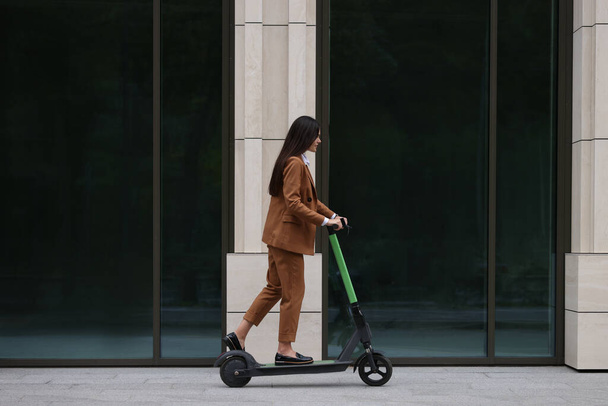 Mujer de negocios montando patinete eléctrico scooter en la calle de la ciudad - Foto, imagen