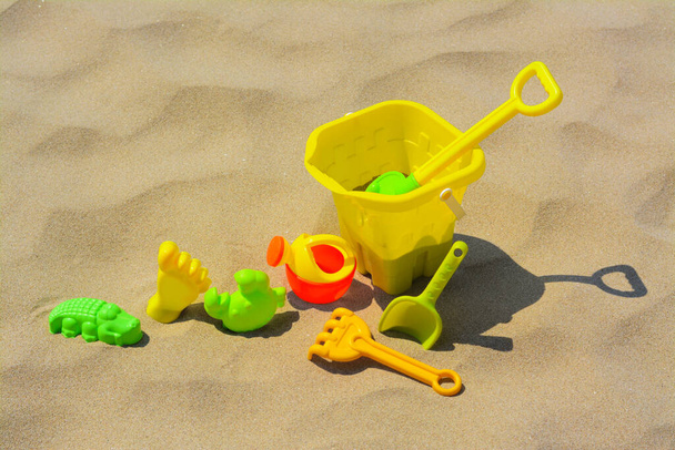 Set of colorful beach toys on sand - Фото, зображення