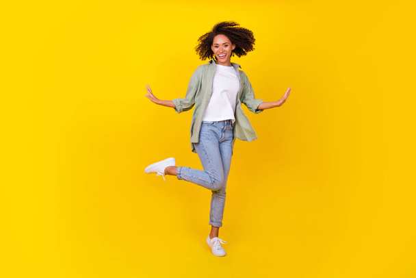 Full length photo of cheery young lady curly hair fooling dancing arms sides wear trendy khaki outfit isolated on yellow color background. - Fotoğraf, Görsel