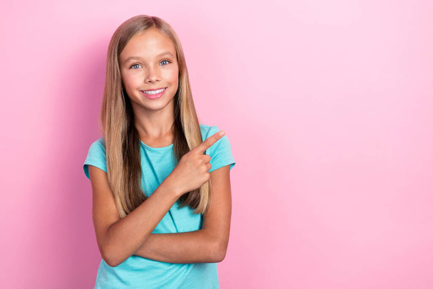 Closeup photo of nice little pretty cheery preteen girl wear aquamarine t-shirt finger pointing empty space good news isolated on pink color background. - Foto, imagen