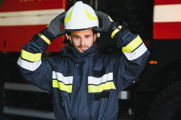 Photo of fireman with gas mask and helmet near fire engine. - Valokuva, kuva