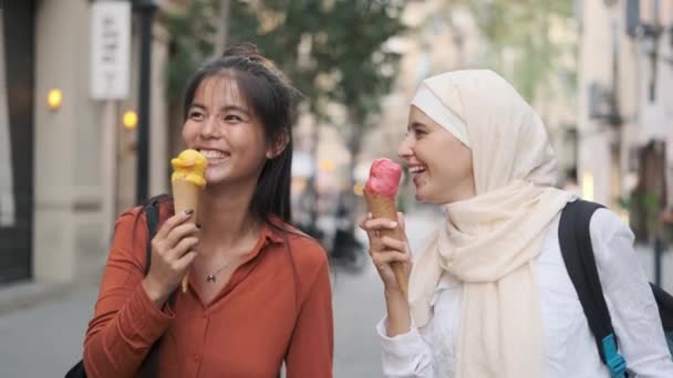 Amigas multiétnicas gostam de comer sorvetes enquanto caminham juntas ao ar livre na rua. Conceito de amizade. - Filmagem, Vídeo
