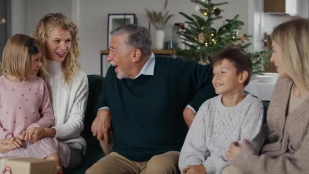 Fehér nagyapa karácsonyi ajándékokat ad az unokáinak. Lövés RED hélium kamerával 8K-ban.    - Felvétel, videó
