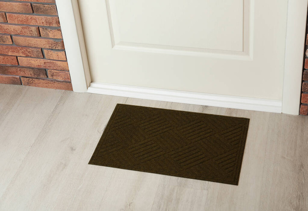 Dark olive door mat on wooden floor in hall - Foto, Imagem