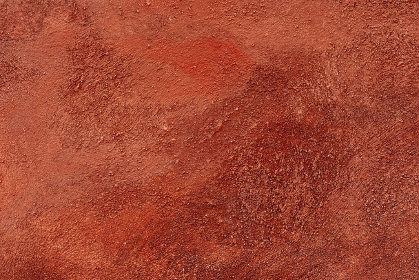 Yeso veneciano, una variedad de revestimiento decorativo de pared, color rojo cálido, imprimación, textura de yeso. pared está hecha de yeso decorativo, pintado con pintura naranja brillante, con rayas y rasguños. - Foto, Imagen