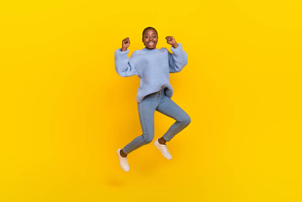 Full size photo of optimistic young nice lady jump wear blue sweater jeans sneakers isolated on grey color background. - Foto, imagen