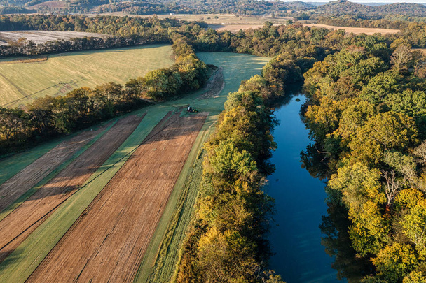 Veduta aerea di un manto erboso con un sistema di irrigazione la zolle per prati e erba verde. La fattoria confina con un bellissimo fiume e foresta nel sud del Tennessee, Stati Uniti. - Foto, immagini