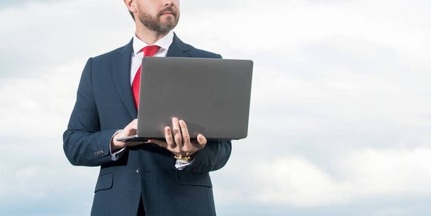 director in suit using laptop on sky background. - Photo, Image