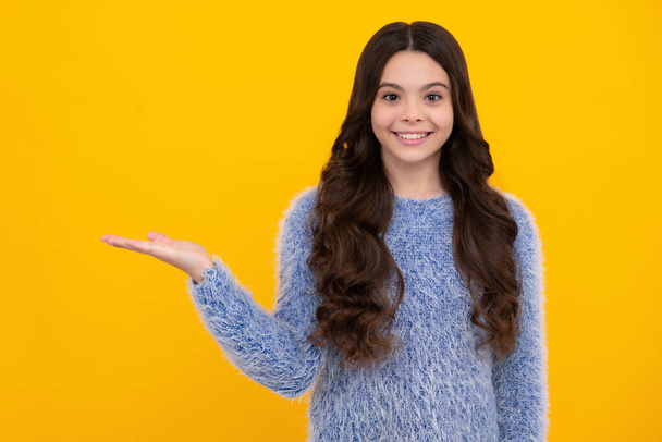 Impressed teenage girl showing recommendation copyspace. Child teenager points away, pointing aside at copy space. Happy teenager, positive and smiling emotions of teen girl - Photo, Image