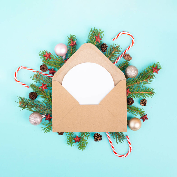 Świąteczne tło świąteczne, koperta z gałązkami jodły, bombki, trzcina cukrowa i szyszki, kartka okolicznościowa sezonu zimowego  - Zdjęcie, obraz