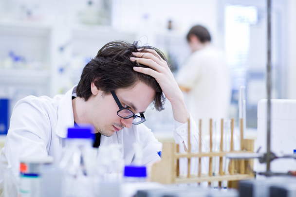 Young male researcher carrying out scientific research in a chem - Foto, afbeelding
