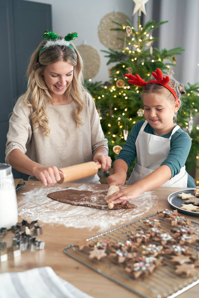 Λευκή γυναίκα με κόρη που φτιάχνει μπισκότα τα Χριστούγεννα στην κουζίνα - Φωτογραφία, εικόνα