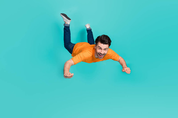 Full body photo of crazy guy playing air gliding flying isolated on cyan color background. - Zdjęcie, obraz