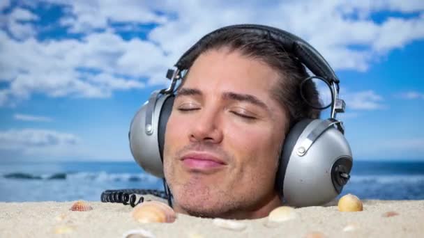 Человек, закопанный по голове на пляже, слушающий музыку в наушниках - Кадры, видео