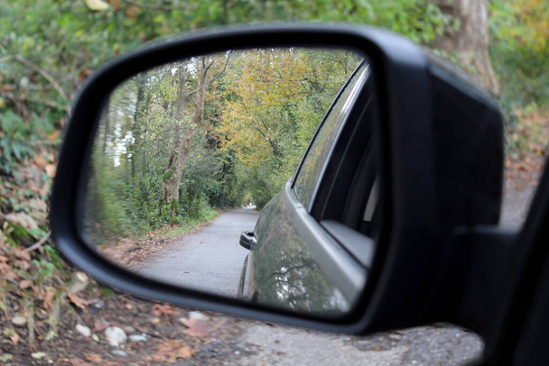 Az autó visszapillantó tükre - autózás vidéken egy őszi napon - Fotó, kép