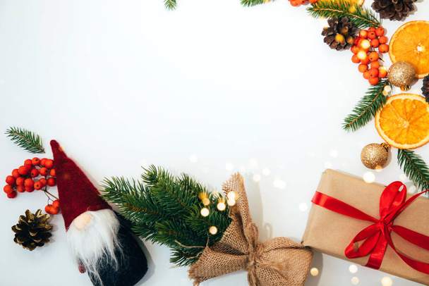 Silvester, Weihnachten Hintergrund, Dekor auf einem weißen Tisch mit Zweigen einer grünen Tanne, Tannenzapfen, Gnome und Orange. Flay - Foto, Bild