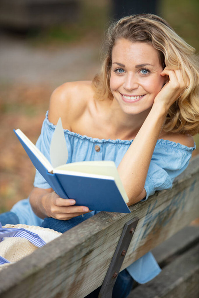 woman on park bench reading a book - Foto, Imagem