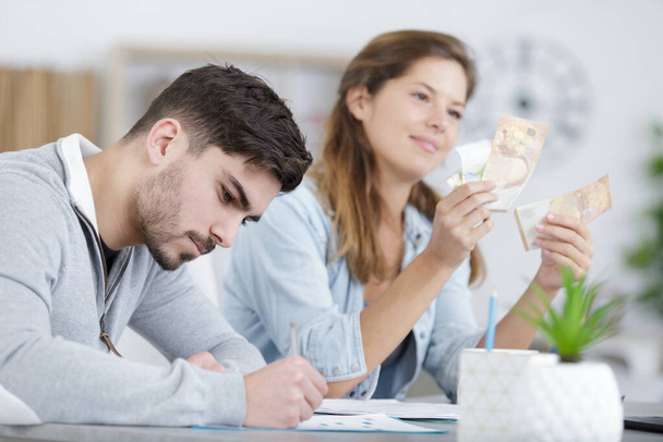 young couple sitting and calculating bills at home - Photo, Image
