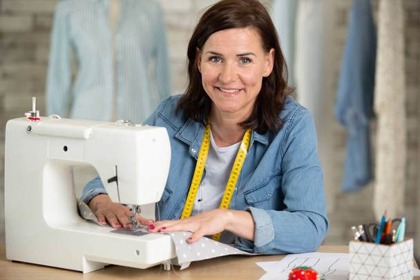 happy woman and sewing workshop - Фото, зображення